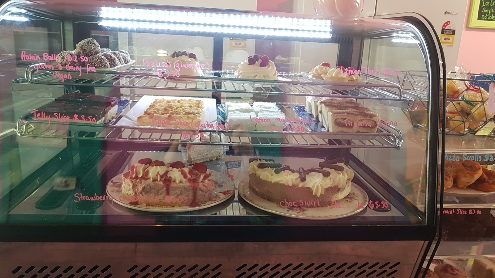 The refrigerated cake cabinet full of cheesecakes