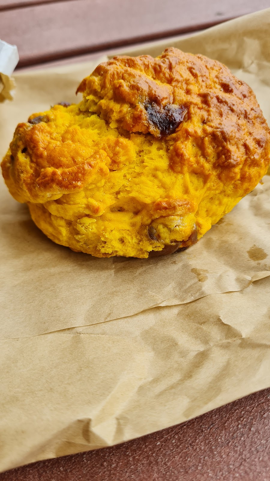 A golden pumpkin scone on brown paper
